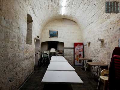 ...all�interno della quale, in fondo a una lunga tavolata e dietro a un �castello� di sedie...